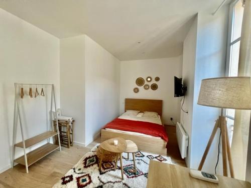 ein kleines Schlafzimmer mit einem Bett und einem Tisch in der Unterkunft Bohème Chic - parking- 80m des arènes in Nîmes