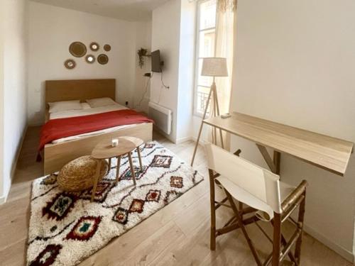 - une chambre avec un lit, une table et une chaise dans l'établissement Bohème Chic - parking- 80m des arènes, à Nîmes