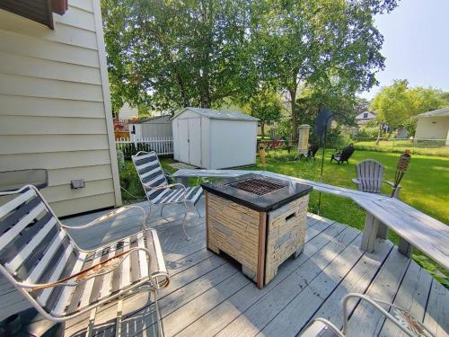 a patio with chairs and a grill on a deck at Huge historic, w/large yard & close to beach in Manistee