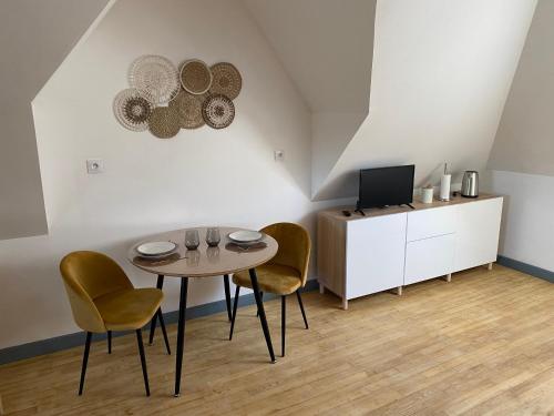 a dining room with a table and chairs and a tv at Studio Cocooning 2eme étage in Saint-Samson-sur-Rance