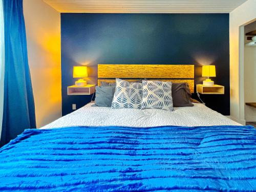 1 dormitorio con 1 cama azul grande y 2 lámparas en Unique Upper Suite Near Lakes, River, Hiking, Fishing, Bike Trails en Chilliwack