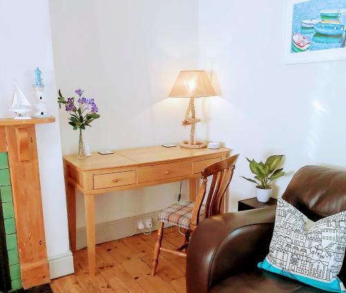 a desk with a lamp and a chair in a room at The Nautical Nest in the heart of Dartmouth in Dartmouth