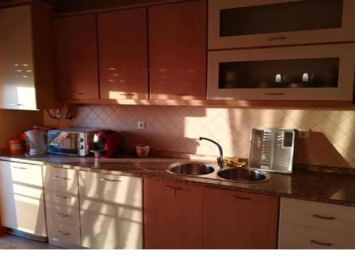 Una encimera de cocina con fregadero y microondas. en Frente barcos do mar, en Vila do Conde