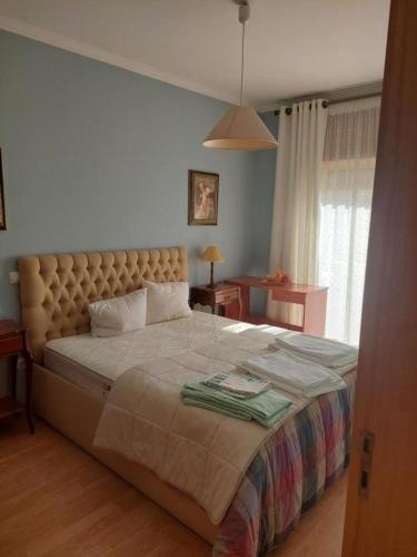 a bedroom with a large bed and a window at Frente barcos do mar in Vila do Conde
