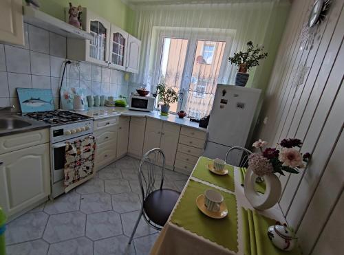 コウォブジェクにあるBoguszのキッチン(冷蔵庫、テーブル、カップ付)