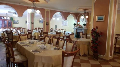 una sala da pranzo con tavoli e sedie in un ristorante di HOTEL RISTORANTE DEGLI AMICI a Mongiana