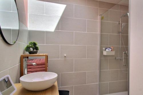 La salle de bains est pourvue d'un lavabo blanc et d'une douche. dans l'établissement So Chic Kerfily, à Kerfily