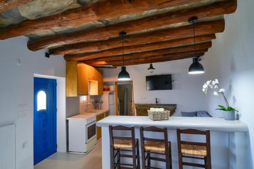 a kitchen with a white counter and a blue door at K vineyard house in Apróvaton