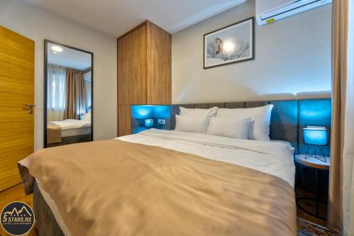 ein Schlafzimmer mit einem großen Bett und einem Spiegel in der Unterkunft 5 STARS - Luxury Premium WELLNESS RESORT Zlatibor in Zlatibor
