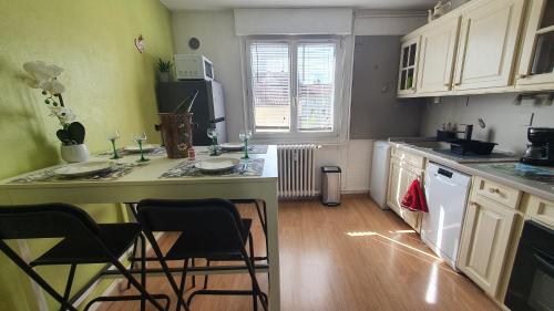 a kitchen with a counter and chairs in it at Le Bienvenue à Colmar - Parking Privé Inclus, Centre à Deux Pas in Colmar