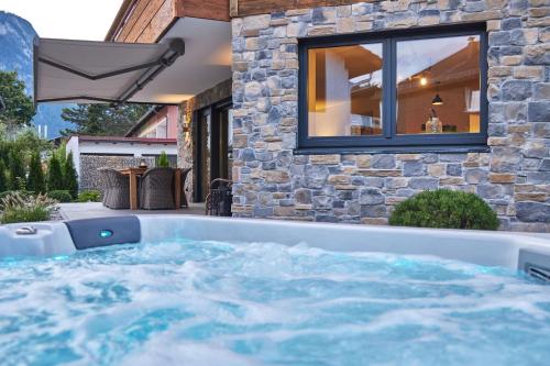 a hot tub in the backyard of a house at Sunshine Apartment Spirit of Deer in Garmisch-Partenkirchen