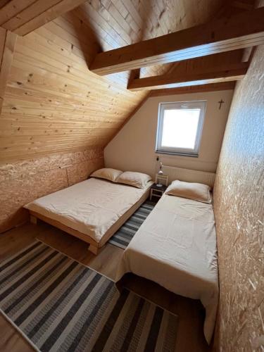 two beds in a small room with a window at Halka Apartment 4 in Rabčice