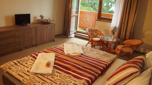 a hotel room with a bed with towels on it at Penzión Zlatny Potok in Mutné
