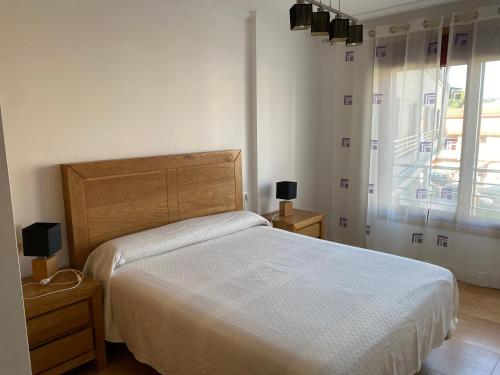 Un dormitorio con una cama grande y una ventana en Apartamento Portonovo (Sanxenxo), en Paxarinas