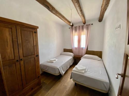 1 dormitorio con 2 camas y ventana. en Casa de las Nieves, en Pitres