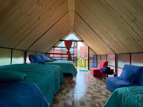 Zimmer mit 3 Betten und 2 Stühlen in einem Zelt in der Unterkunft Hospedaje Villa Rosita Suesca in Suesca