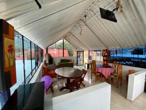 uma área de refeições com uma mesa e cadeiras numa tenda em Hospedaje Villa Rosita Suesca em Suesca