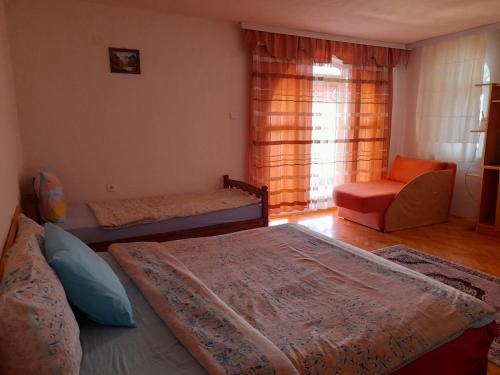 a bedroom with three beds and a chair and a window at Villa Gjorgi in Ohrid