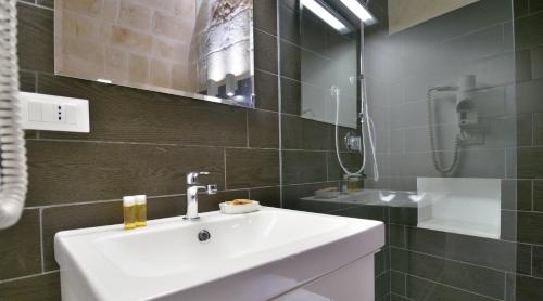 a bathroom with a white sink and a mirror at Palazzo Kapece in Monopoli