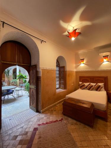 a bedroom with a bed and a patio with a table at Riad La Calèche & SPA in Marrakesh