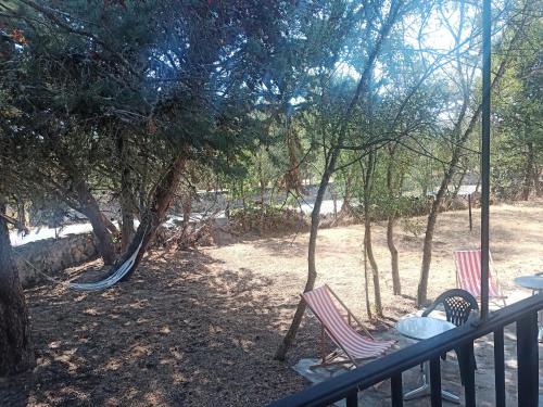 a porch with two chairs and a swing at Casa con Encanto Mitos in Pelayos del Arroyo