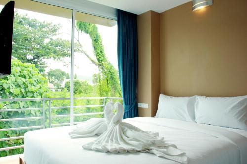 1 dormitorio con 1 cama blanca y ventana en Cheeky Monkey's Samui, en Chaweng