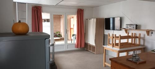 Il comprend une cuisine équipée d'un réfrigérateur et d'une table avec une chaise. dans l'établissement Le paysage - Le studio PMR, à Arsac-en-Velay