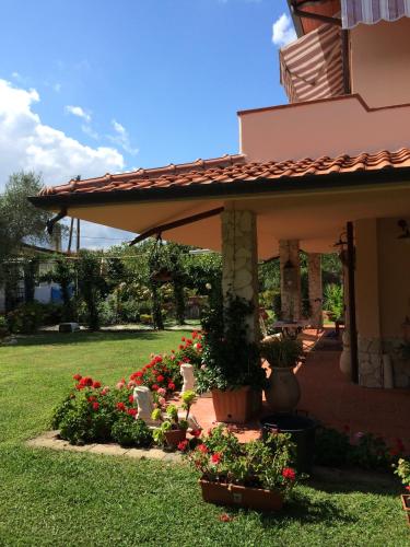 a porch of a house with flowers in a yard at B&B Il Portico in Sarzana