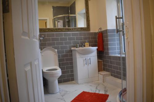 a bathroom with a toilet and a sink and a mirror at Florence House in Denbigh