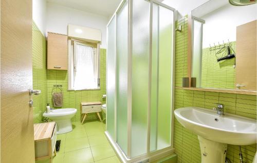 a green bathroom with a sink and a toilet at 3 Bedroom Lovely Apartment In Calatabiano in Calatabiano