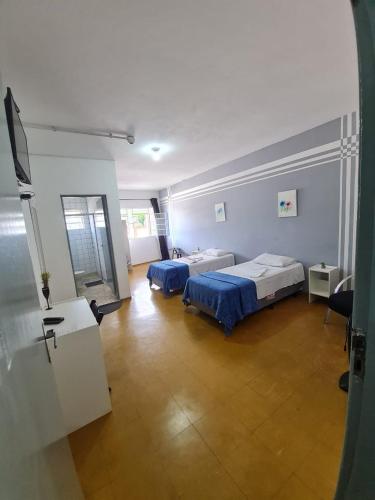 a room with two beds and a television in it at Hotel Nobre Requinte in Arujá
