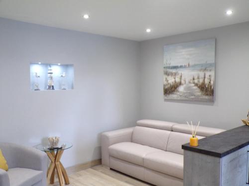 a living room with a couch and a painting on the wall at 4TheDome- Deluxe ground floor apartment opposite the sea in Barton on Sea
