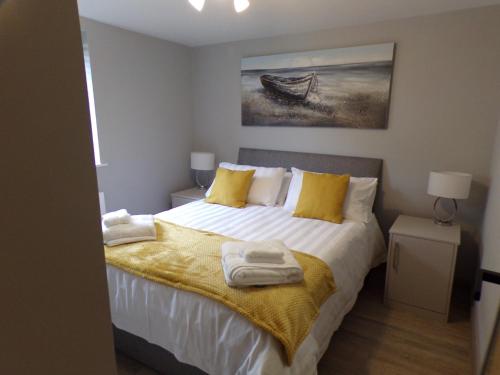 1 dormitorio con 1 cama con toallas en 4TheDome- Deluxe ground floor apartment opposite the sea en Barton on Sea