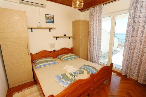 a bedroom with a bed and a large window at Apartments with parking space Zivogosce - Porat, Makarska - 10032 in Živogošće