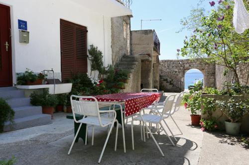 a table with chairs and a red and white table cloth at Apartments by the sea Igrane, Makarska - 10033 in Igrane