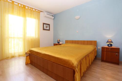 sypialnia z dużym łóżkiem i oknem w obiekcie Apartments by the sea Igrane, Makarska - 10033 w mieście Igrane