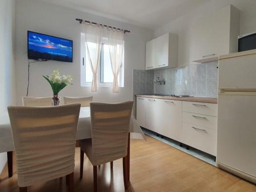 kuchnia ze stołem i krzesłami w pokoju w obiekcie Apartments by the sea Igrane, Makarska - 10033 w mieście Igrane
