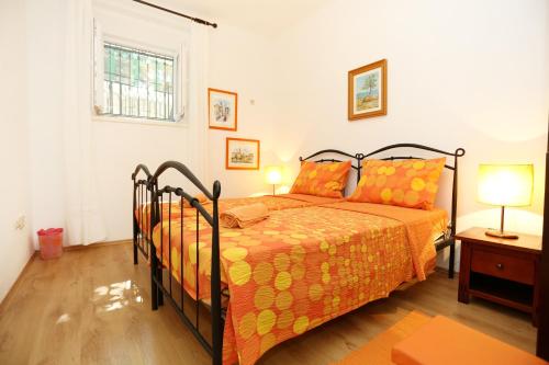 a bedroom with a bed with an orange bedspread at Apartments with WiFi Split - 10243 in Split