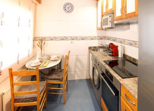 a small kitchen with a small table and a sink at Sestao, Vivienda Turística Renovada con Terraza y WIFI in Sestao