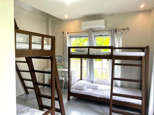 two bunk beds in a room with a window at TeSario Retreat in General Luna