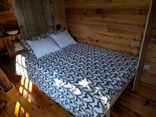 a bed in a room with a wooden wall at Moinho de Pedra Má in Arouca