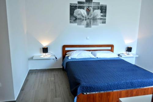 a bedroom with a bed with a blue comforter and two lamps at Apartments by the sea Brna, Korcula - 10065 in Brna