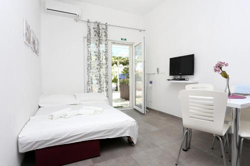 a bedroom with a bed and a table and a tv at Apartments by the sea Duce, Omis - 10304 in Duće