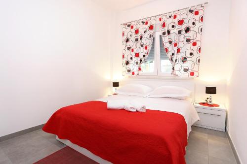 Apartment Duce 10304b في دوسيه: غرفة نوم بسرير احمر وبيض مع نافذة