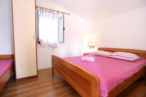 a bedroom with a bed with a pink blanket at Apartments by the sea Zuronja, Peljesac - 10123 in Brijesta