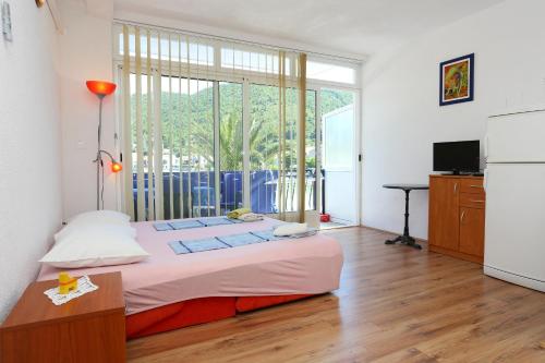 a bedroom with a bed and a large window at Apartments by the sea Zuljana, Peljesac - 10218 in Žuljana