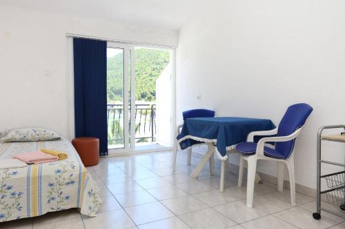 a room with a table and chairs and a bed at Apartments by the sea Zuljana, Peljesac - 10218 in Žuljana