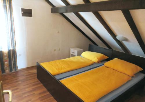 two beds in a room with yellow pillows at Apartments by the sea Drace, Peljesac - 10126 in Drače