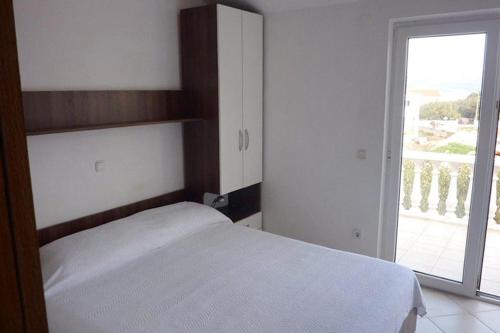 a bedroom with a white bed and a large window at Apartment Drace 10127b in Drače