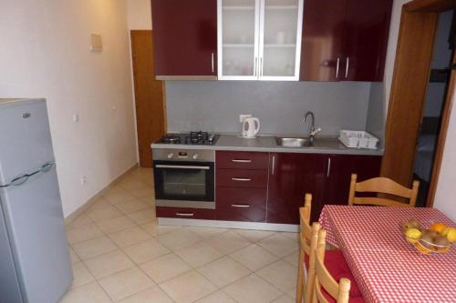 a kitchen with a table and a sink and a stove at Apartment Drace 10127c in Drače
